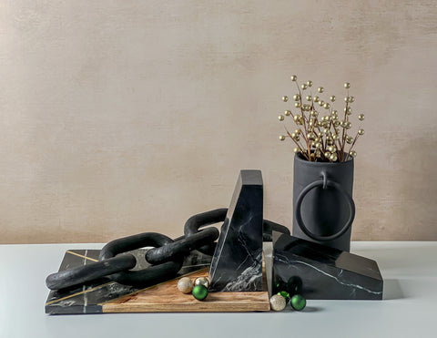Black home decor items including a vase, tray, wooden links and marble bookends